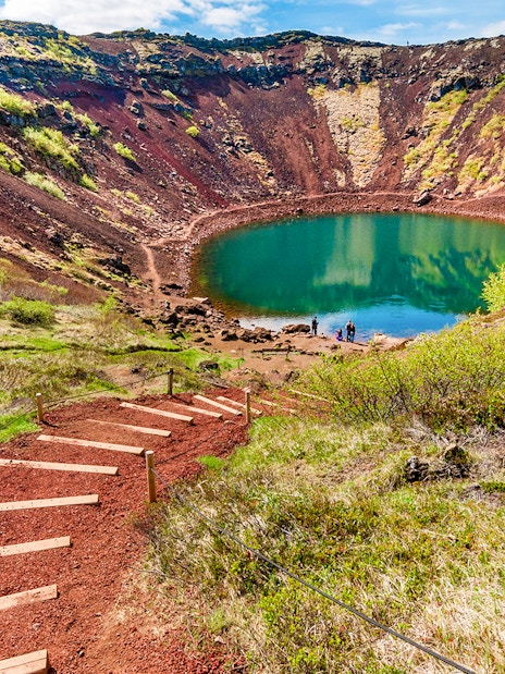 Kerid Crater with turquoise lake and surrounding red volcanic rock in Iceland.