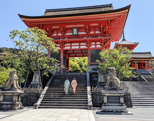 Two people in kimonos ascend steps at Kiyomizu-dera Temple, Kyoto.