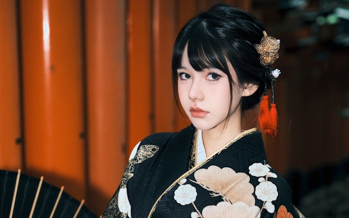 Woman in traditional Japanese kimono with floral patterns and hair ornament.