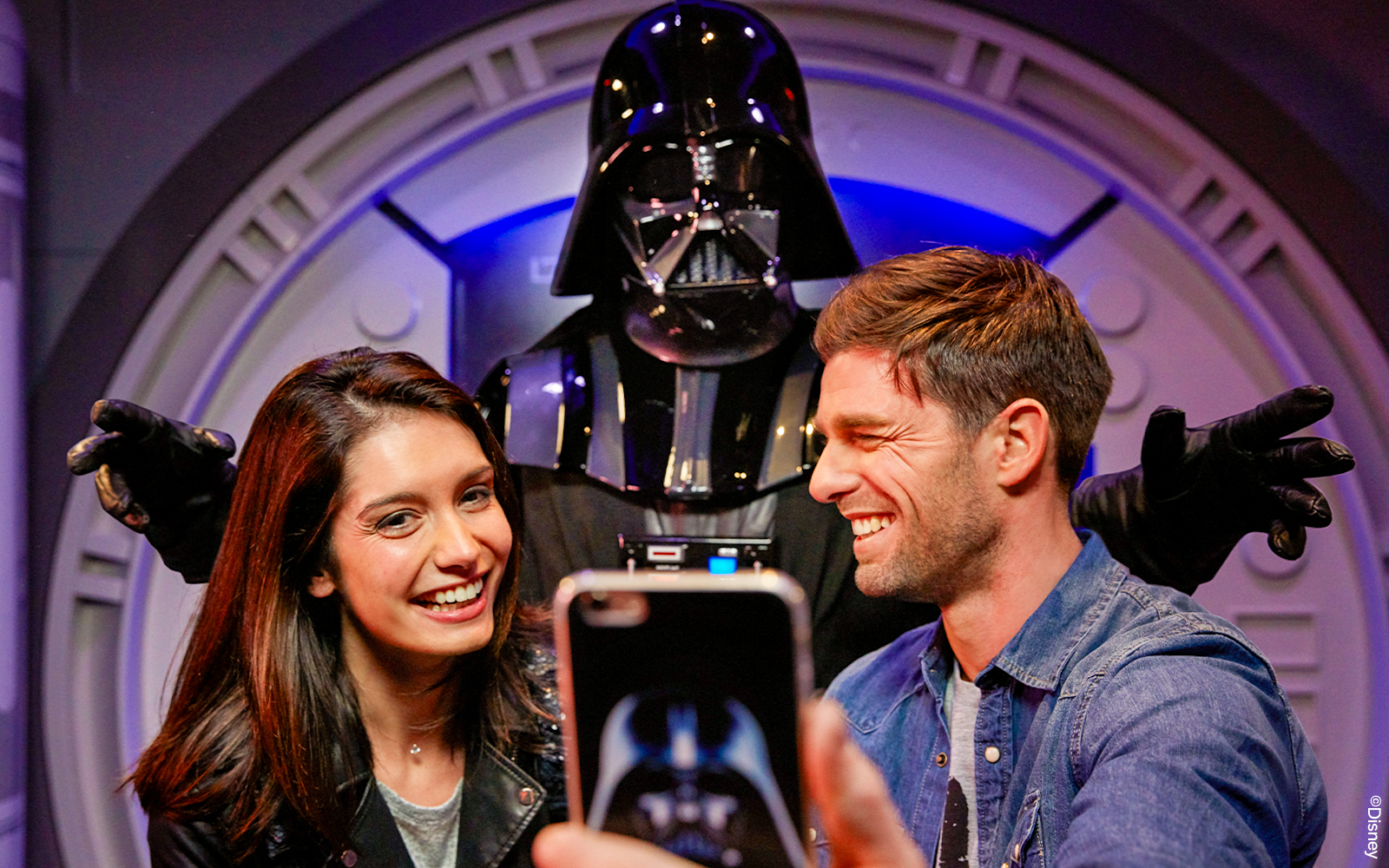 Guests taking a selfie with a Star Wars character at Disneyland Paris.