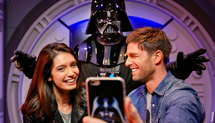 Guests taking a selfie with a Star Wars character at Disneyland Paris.