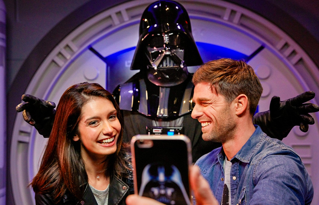 Guests taking a selfie with a Star Wars character at Disneyland Paris.