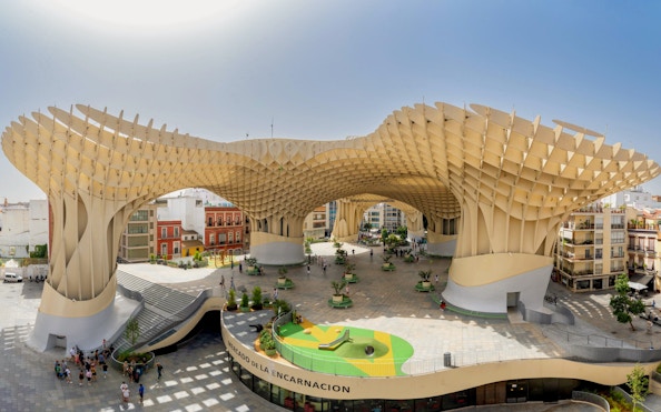 Visitors exploring the wooden structure of Setas de Sevilla, Spain.