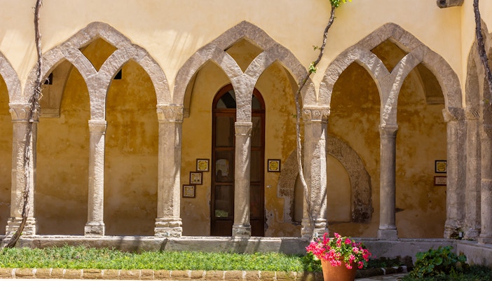 Chiostro di San Francisco courtyard with arches, part of Rome to Amalfi day trip experience.