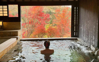 Chartered hot spring bath with view of autumn foliage in Japan.