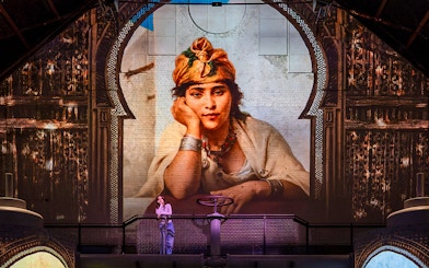 Exhibition visitor viewing large projected portrait at Fabrique des Lumières, Kingdom of the Pharaohs.