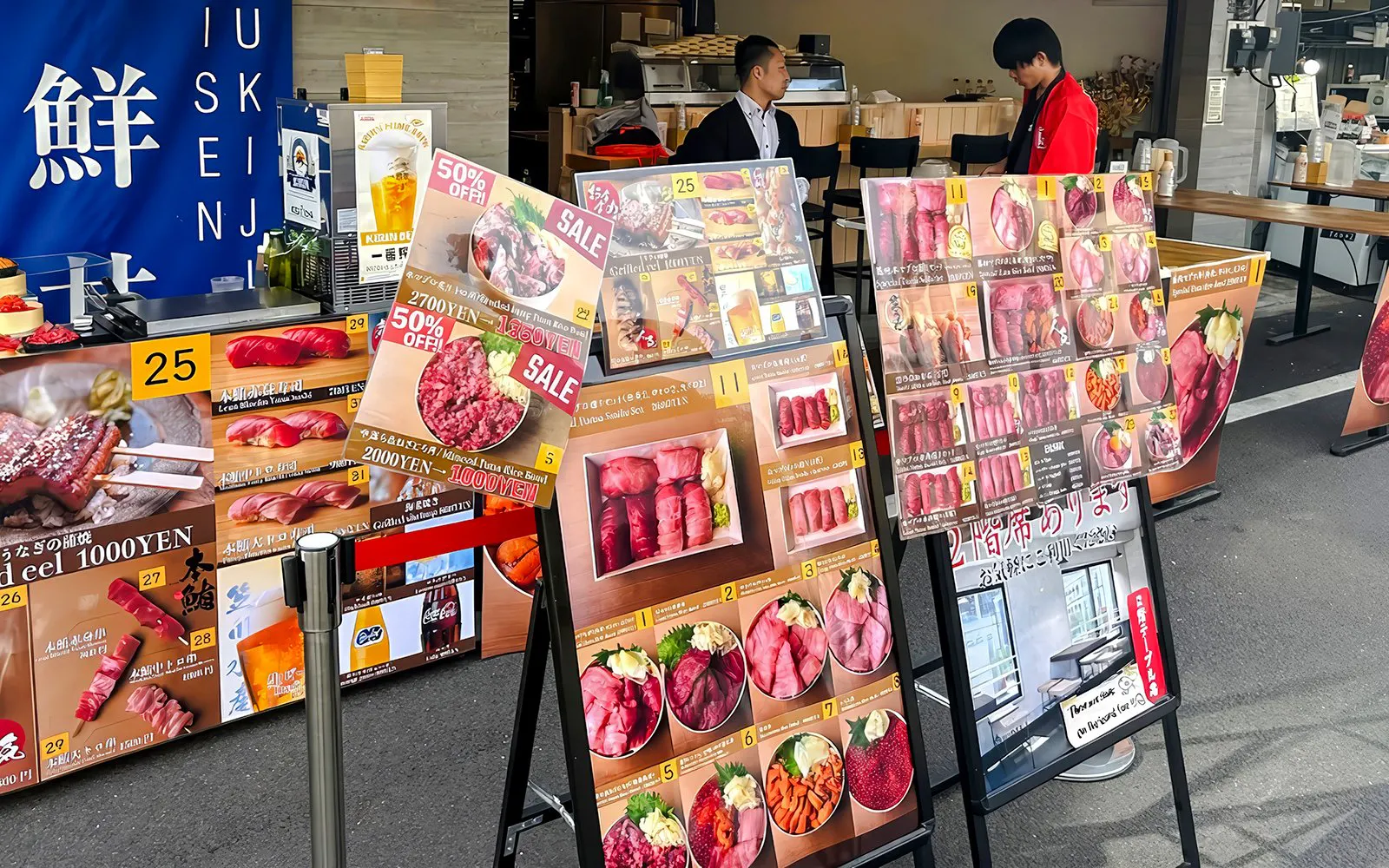 Food stall menu displays at Tsukiji Market, featuring sushi and seafood options.
