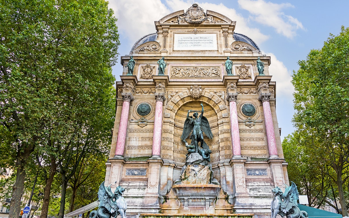 Saint-Michel Fountain in Paris' Latin Quarter with ornate sculptures and columns.