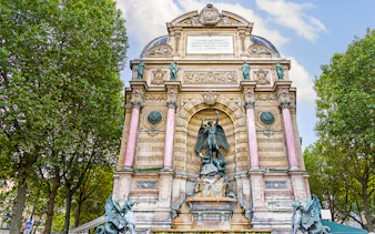 Saint-Michel Fountain in Paris' Latin Quarter with ornate sculptures and columns.
