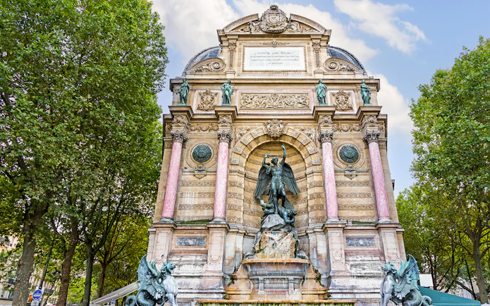 Saint-Michel Fountain in Paris' Latin Quarter with ornate sculptures and columns.