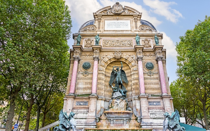 Saint-Michel Fountain in Paris' Latin Quarter with ornate sculptures and columns.
