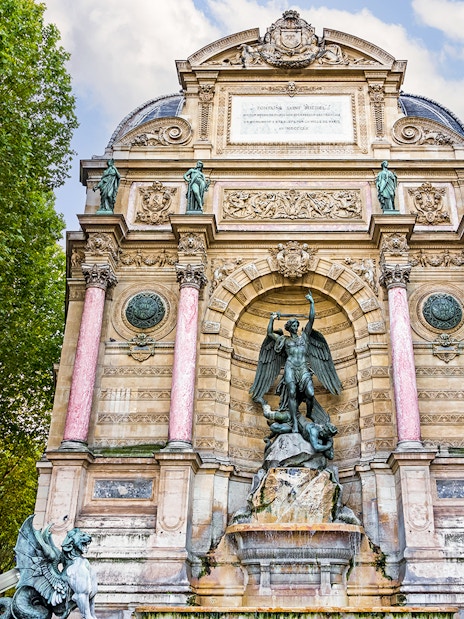Saint-Michel Fountain in Paris' Latin Quarter with ornate sculptures and columns.