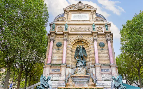 Saint-Michel Fountain in Paris' Latin Quarter with ornate sculptures and columns.