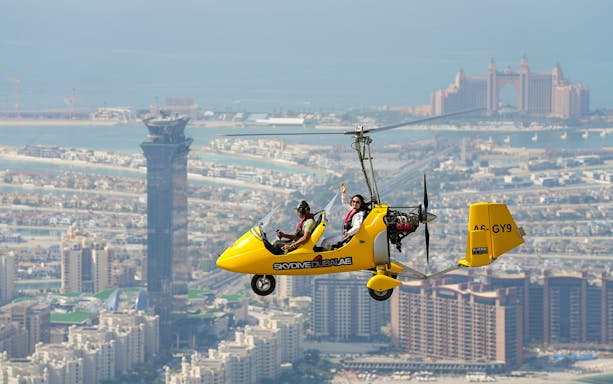 Gyrocopter flying over Dubai with Atlantis Hotel in the background.