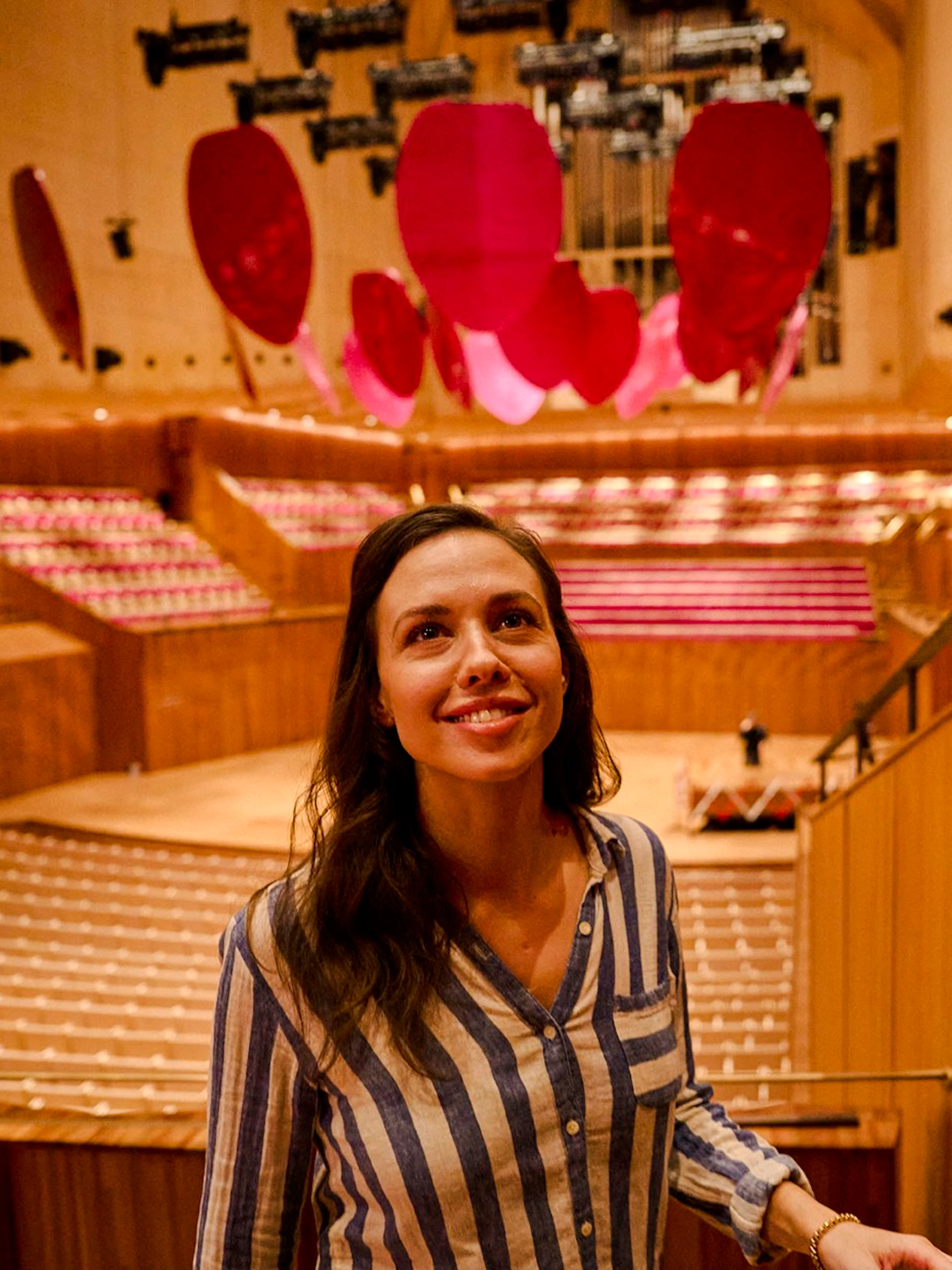 Visitor on a guided tour inside Sydney Opera House, admiring the concert hall.