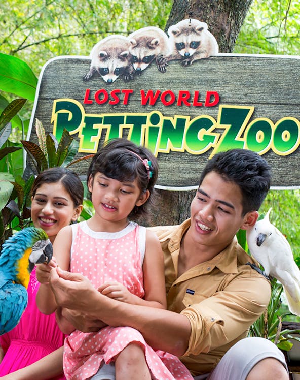 Family interacting with parrots at Lost World of Tambun Petting Zoo.