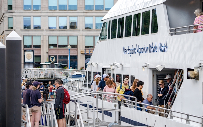 Guests boarding New England Aquarium Whale Watch catamaran in Boston.