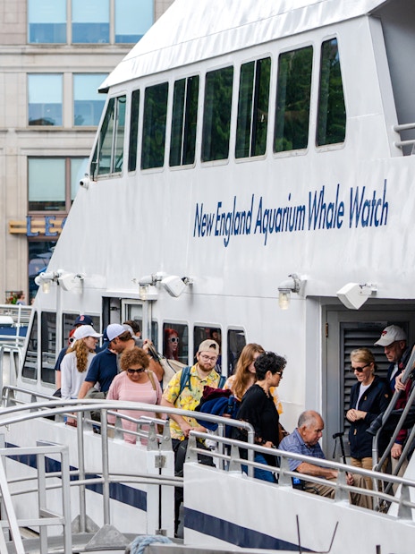 Guests boarding New England Aquarium Whale Watch catamaran in Boston.