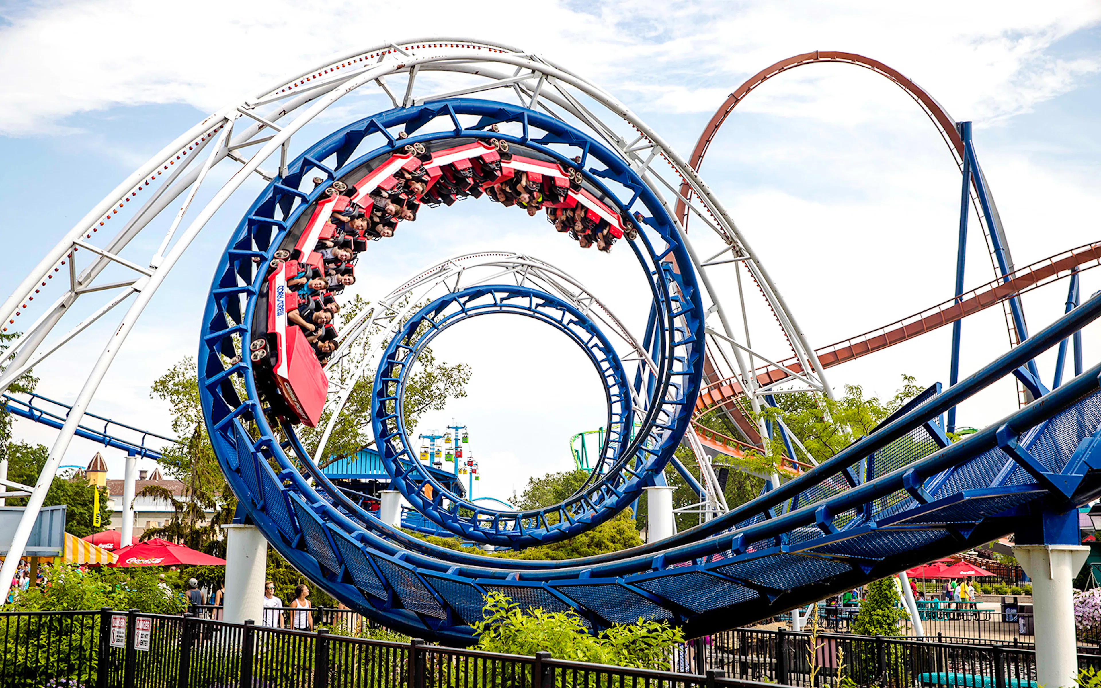 Corkscrew roller coaster looping at Cedar Point amusement park.