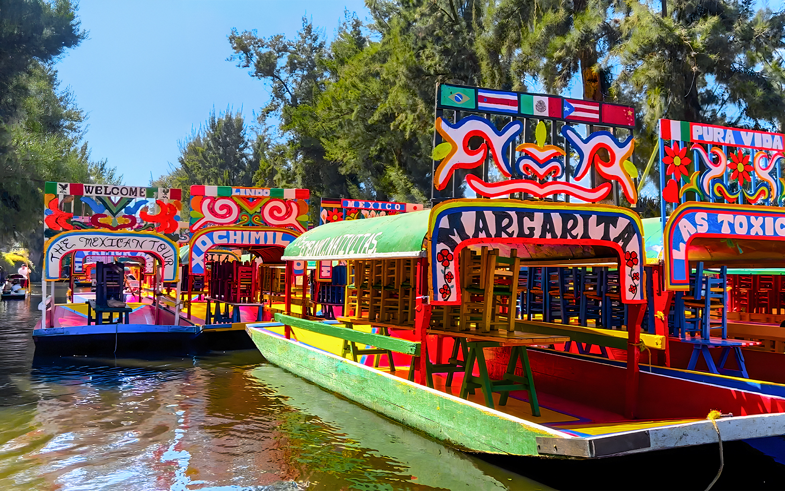 Colorful trajineras on a canal during a Xochimilco tour in Mexico City.