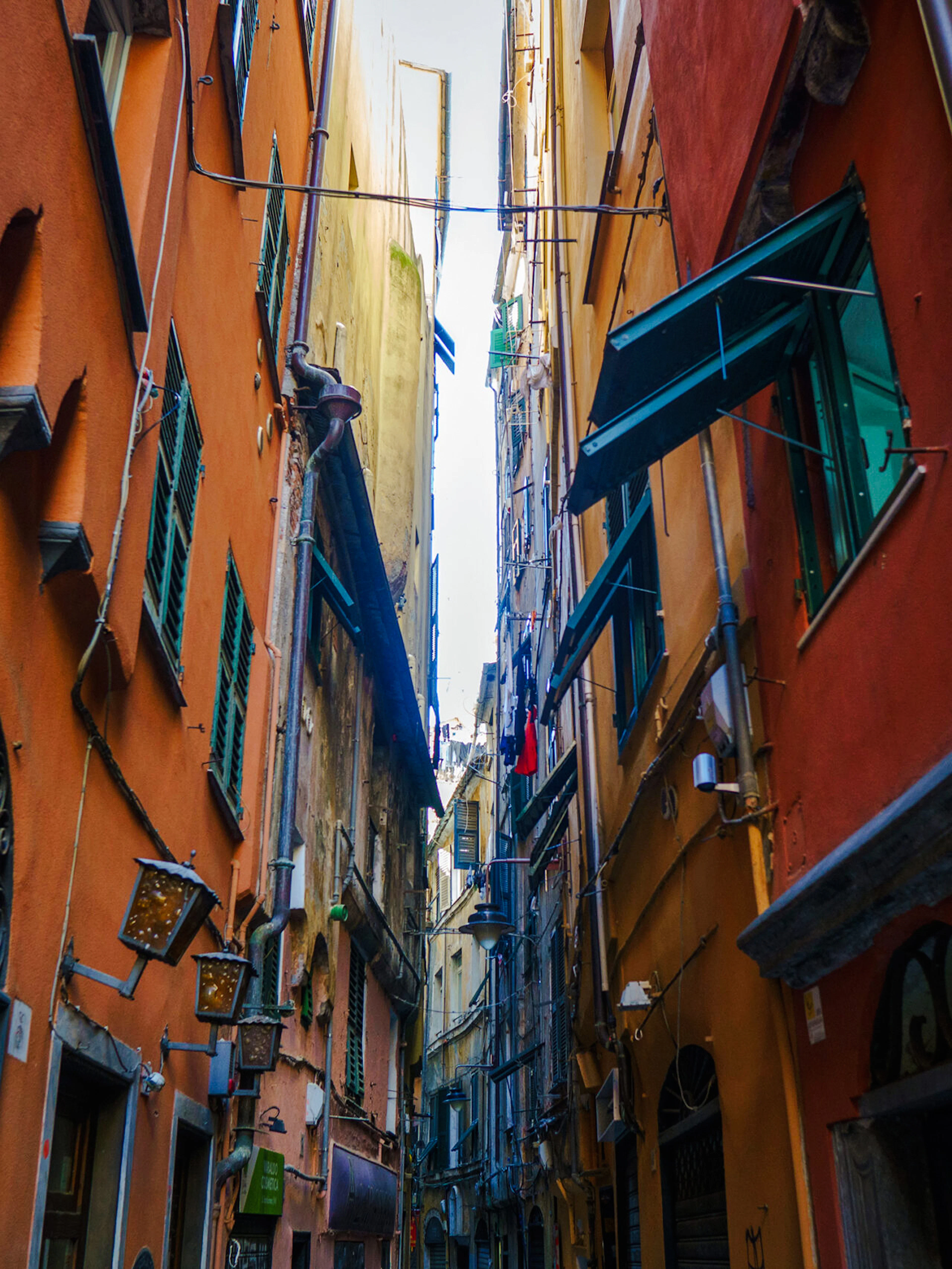 Narrow alleyway with colorful buildings in Genoa, Italy, part of a walking dinner tour.