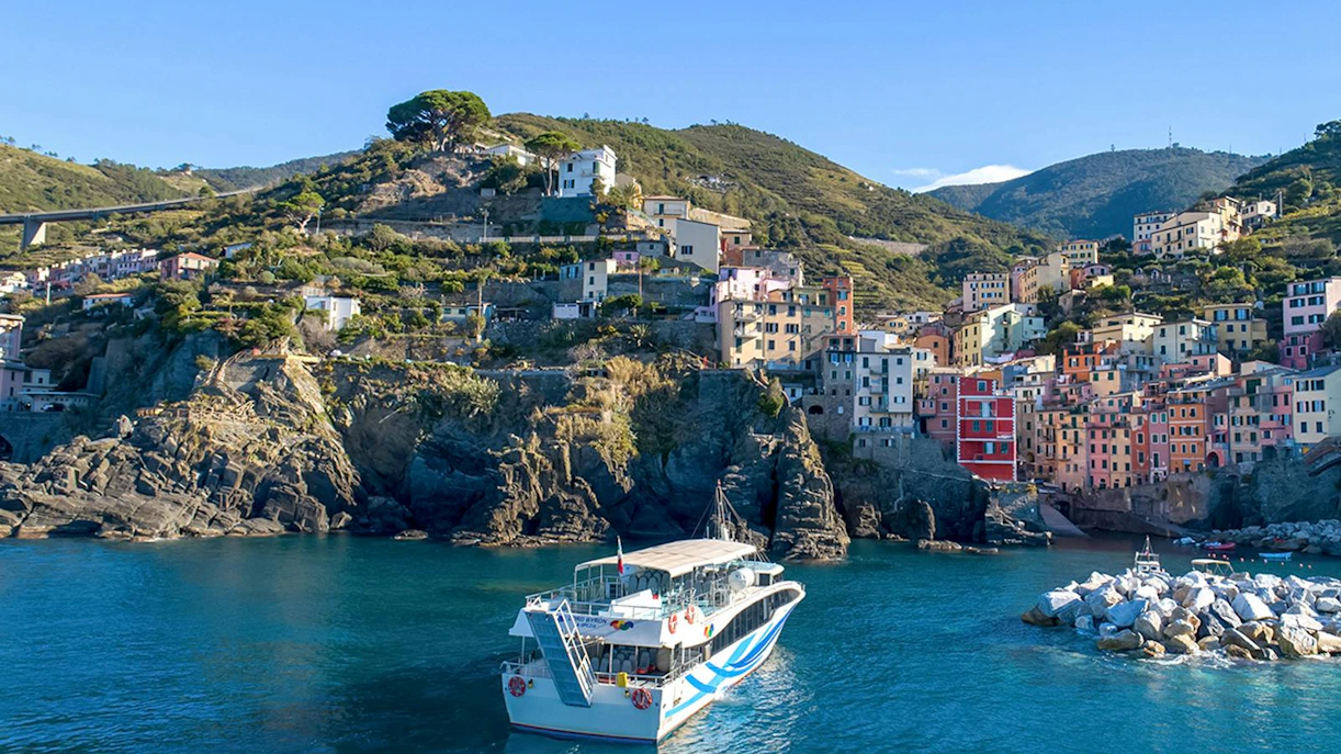 Cruise ship approaching colorful cliffside village in Cinque Terre, Italy.