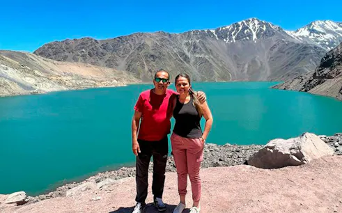 Visitors at Embalse El Yeso with Andes mountains in the background, Santiago tour.