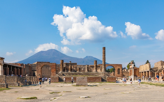 Temple of Giove ruins in Pompeii with Mount Vesuvius in the background.