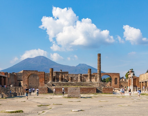 Temple of Giove ruins in Pompeii with Mount Vesuvius in the background.