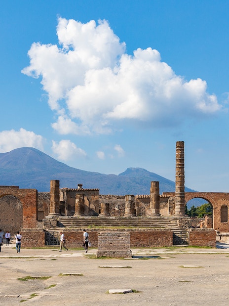 Temple of Giove ruins in Pompeii with Mount Vesuvius in the background.