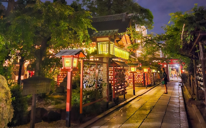 Lantern-lit path in Gion district, Kyoto, Japan, at night with traditional architecture.