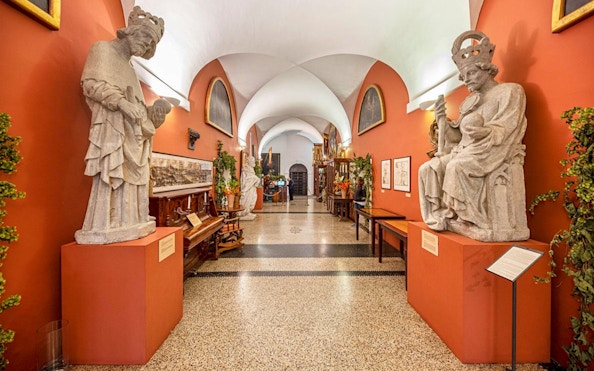 Statues and exhibits inside the Charles Bridge Museum hallway.