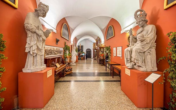 Statues and exhibits inside the Charles Bridge Museum hallway.