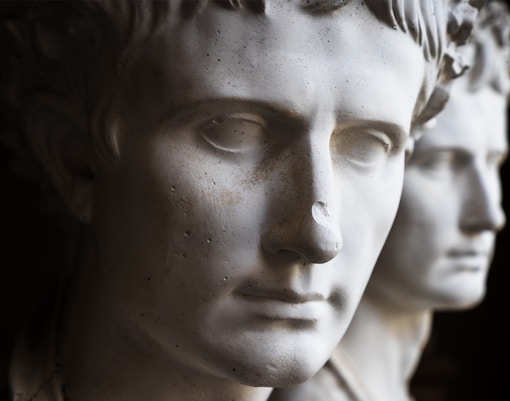 Plaster busts of Roman citizens displayed in a museum setting.