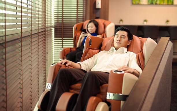 Relaxing in massage chairs at SATS Plaza Premium Lounge, Singapore.