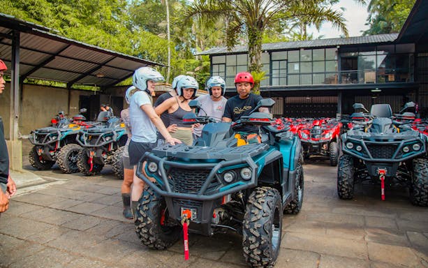 Group preparing for ATV ride in Ubud with guide, surrounded by parked ATVs.