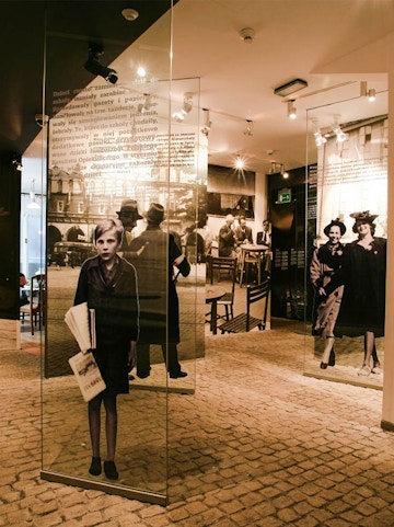 Exhibit inside Oskar Schindler's Factory museum in Krakow, featuring historical photographs and displays.