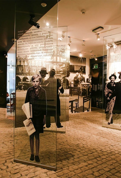 Exhibit inside Oskar Schindler's Factory museum in Krakow, featuring historical photographs and displays.