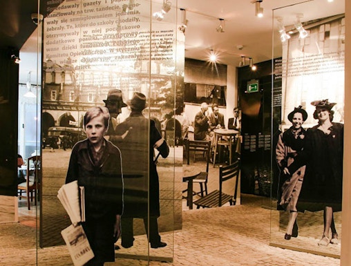 Exhibit inside Oskar Schindler's Factory museum in Krakow, featuring historical photographs and displays.