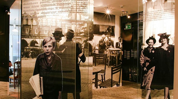 Exhibit inside Oskar Schindler's Factory museum in Krakow, featuring historical photographs and displays.