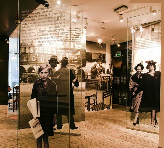 Exhibit inside Oskar Schindler's Factory museum in Krakow, featuring historical photographs and displays.