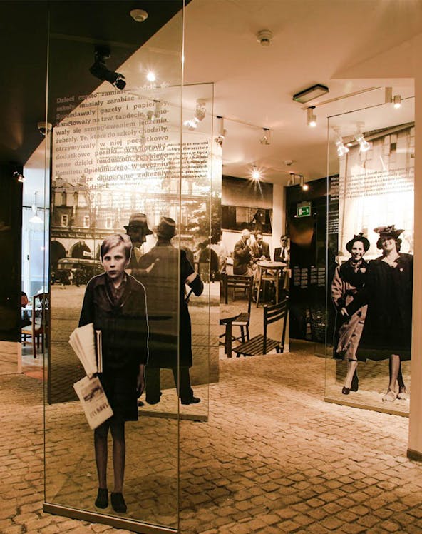 Exhibit inside Oskar Schindler's Factory museum in Krakow, featuring historical photographs and displays.