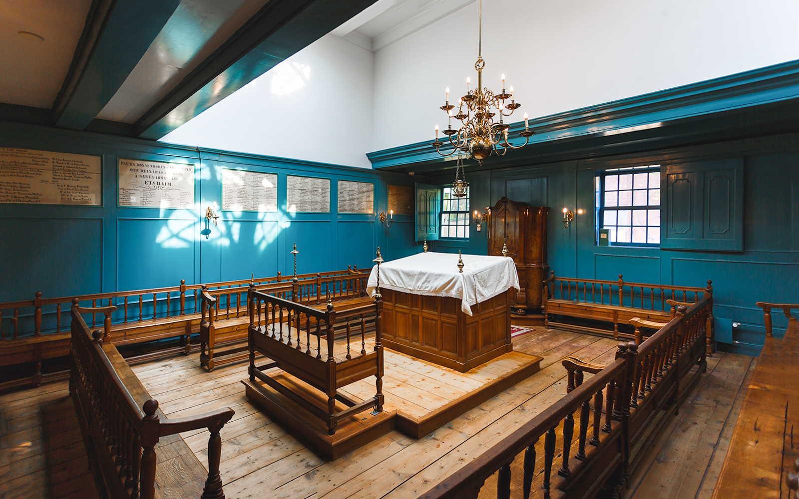 Interior of Anne Frank House with wooden benches and a chandelier, Amsterdam tour.
