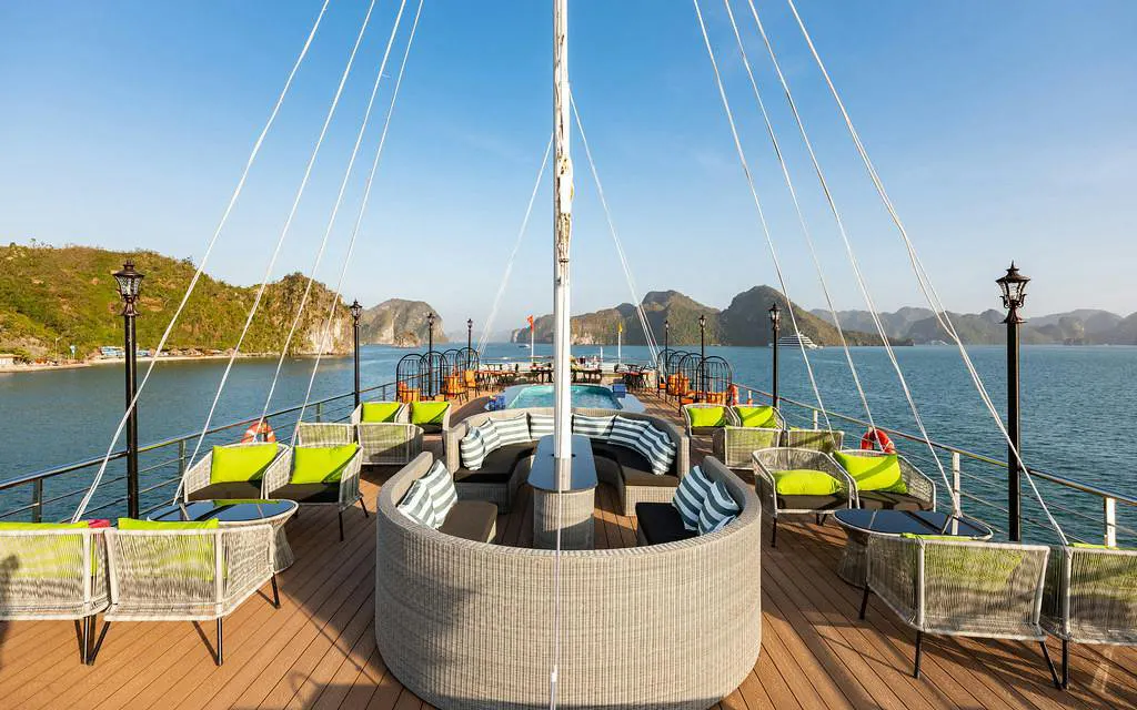 La Casta cruise deck with seating, Ha Long Bay limestone islands in background.