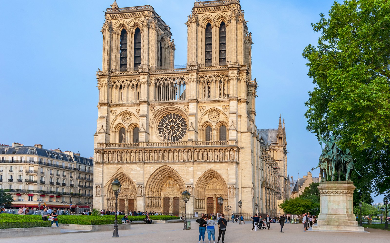 Notre Dame de Paris Cathedral facade with visitors in Paris.