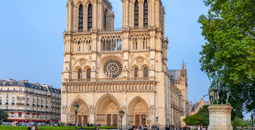 Notre Dame de Paris Cathedral facade with visitors in Paris.