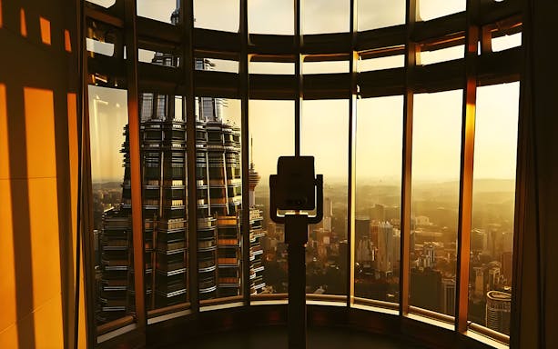 Binoculars on Petronas Twin Towers observation deck overlooking Kuala Lumpur at sunset.