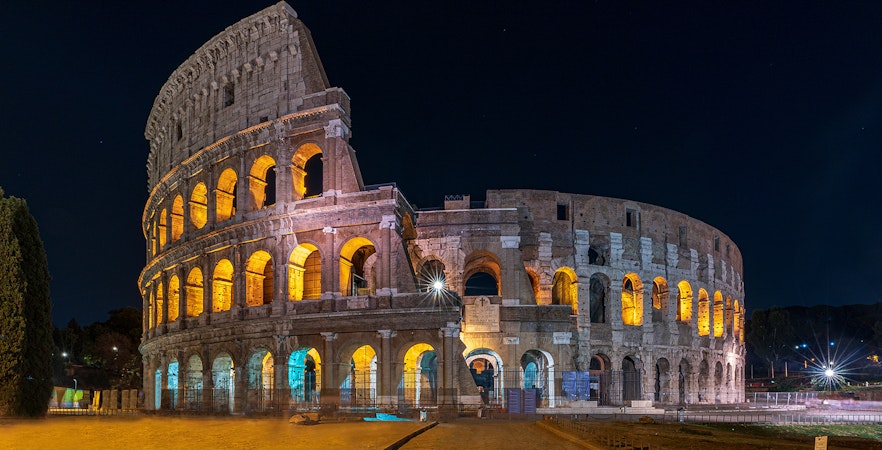 Colosseum illuminated at night during an evening guided tour with arena floor access.