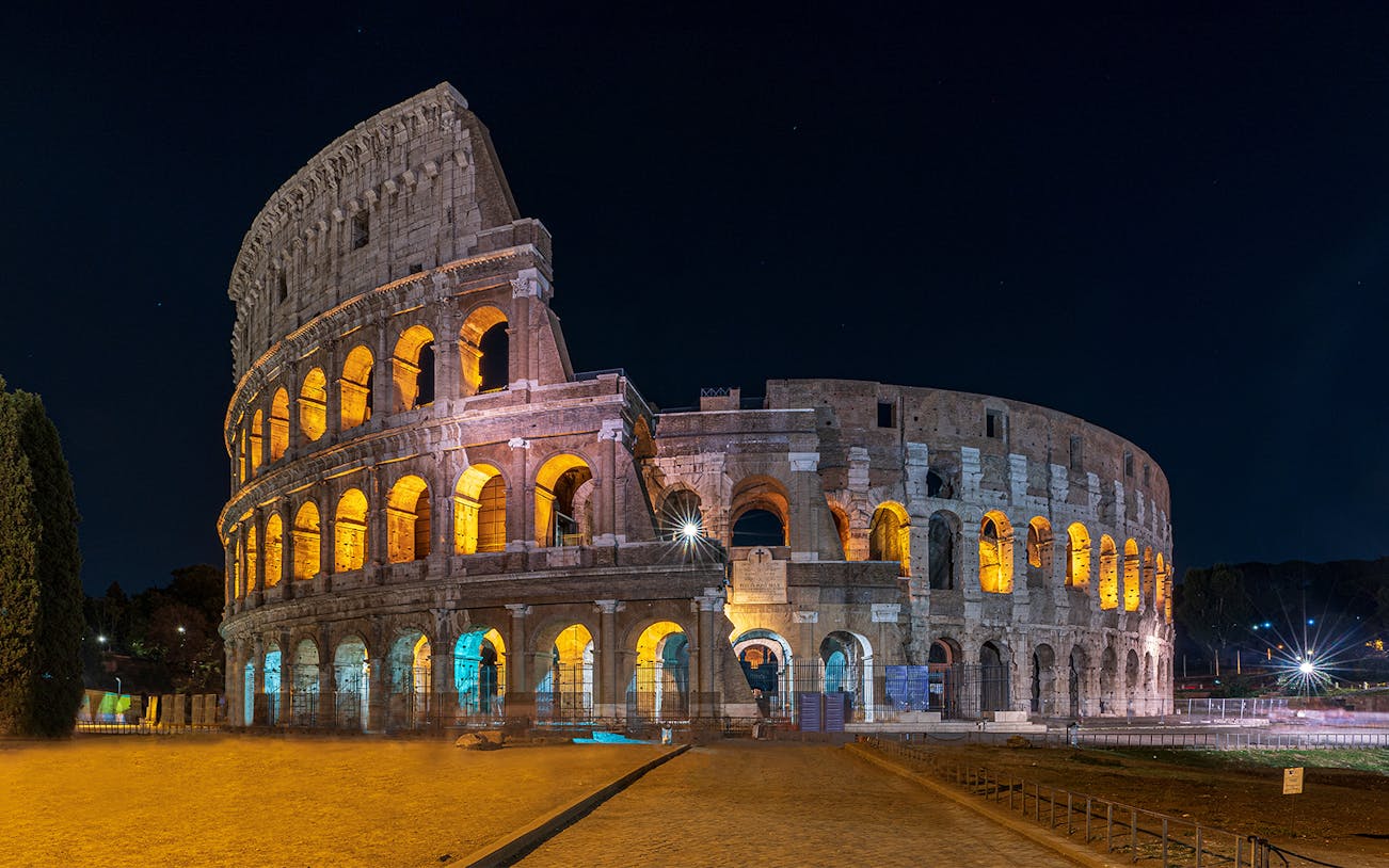Colosseum illuminated at night during an evening guided tour with arena floor access.