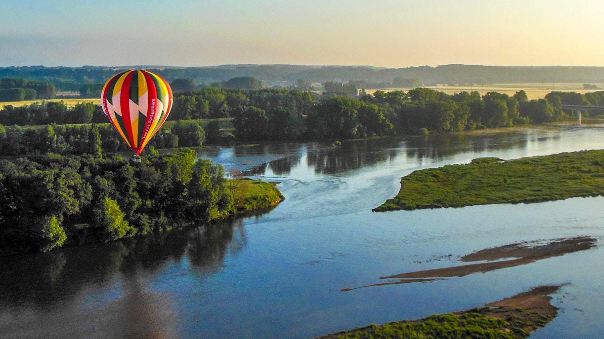 Loire Valley hot air balloon floating over vineyards and chateaux in France.